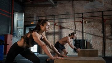 A man and a woman working out in a Pilates class wearing fitness shoes.